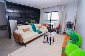 A modern living room with a sofa, a coffee table, and a dining area with chairs. - Cozy & Stylish Studio (Nairobi)