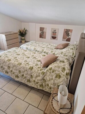 A bedroom with a bed, a bedside table, a chair, and a wall with three artworks. - Apartment 'Tra Mare E Monti' with Mountain View, Wi-Fi and Air Conditioning (Paglieta)