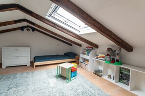 A child's bedroom with a bunk bed, a small table, and shelves with toys and books. - Borgo 1660 - Charming Residence (Castellabate)
