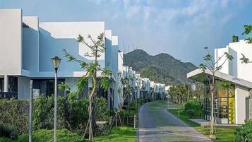 A pathway leading to modern buildings with a mountain backdrop.