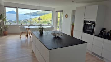 Una cocina moderna con un ventanal grande, un comedor y vistas al paisaje.