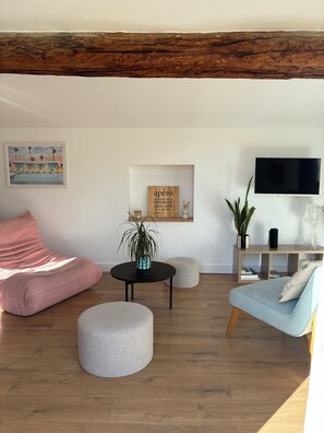 A living room with a wooden ceiling, a flat-screen TV, a sofa, a chair, a coffee table, and a small plant. - Rooftop terrace in the heart of Aix-en-Provence (Aix-en-Provence)