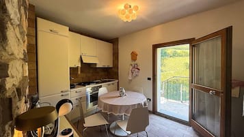 A compact kitchen with a dining area, a stove, and a table with chairs.