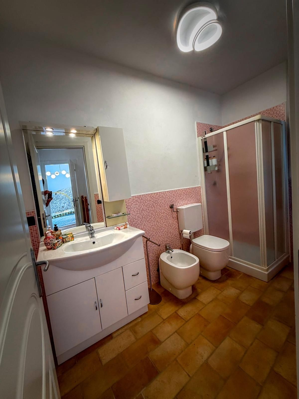 Un baño con lavamanos, inodoro, bidé y ducha.
