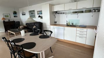 Un espace de vie compact comprenant un coin repas, une kitchenette et un canapé.