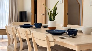 A dining area with a wooden table, beige chairs, and blue dinnerware.