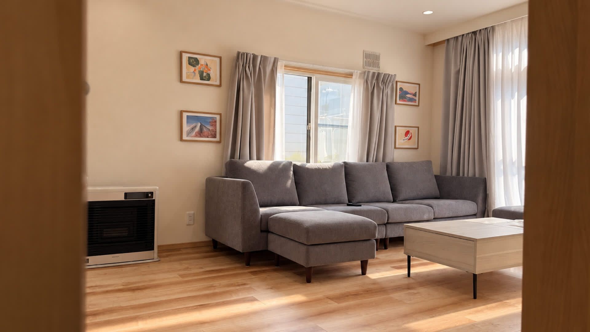 A modern living room with a grey sectional sofa, a white coffee table, and a radiator.