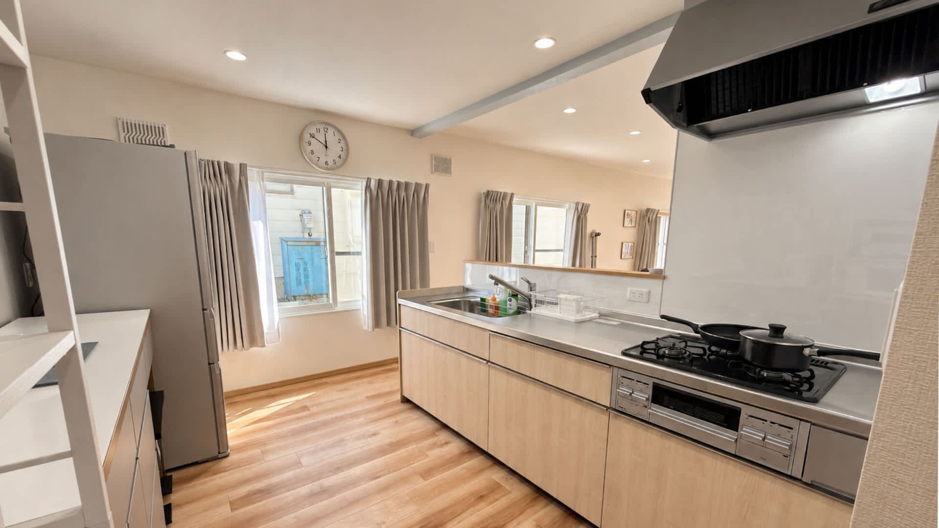 A modern kitchen with a gas stove, stainless steel appliances, and wooden cabinets.