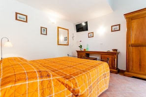 A bedroom with a bed, a desk, a TV, and a wardrobe. - Il Giardinetto Rooms  (Ferrara)