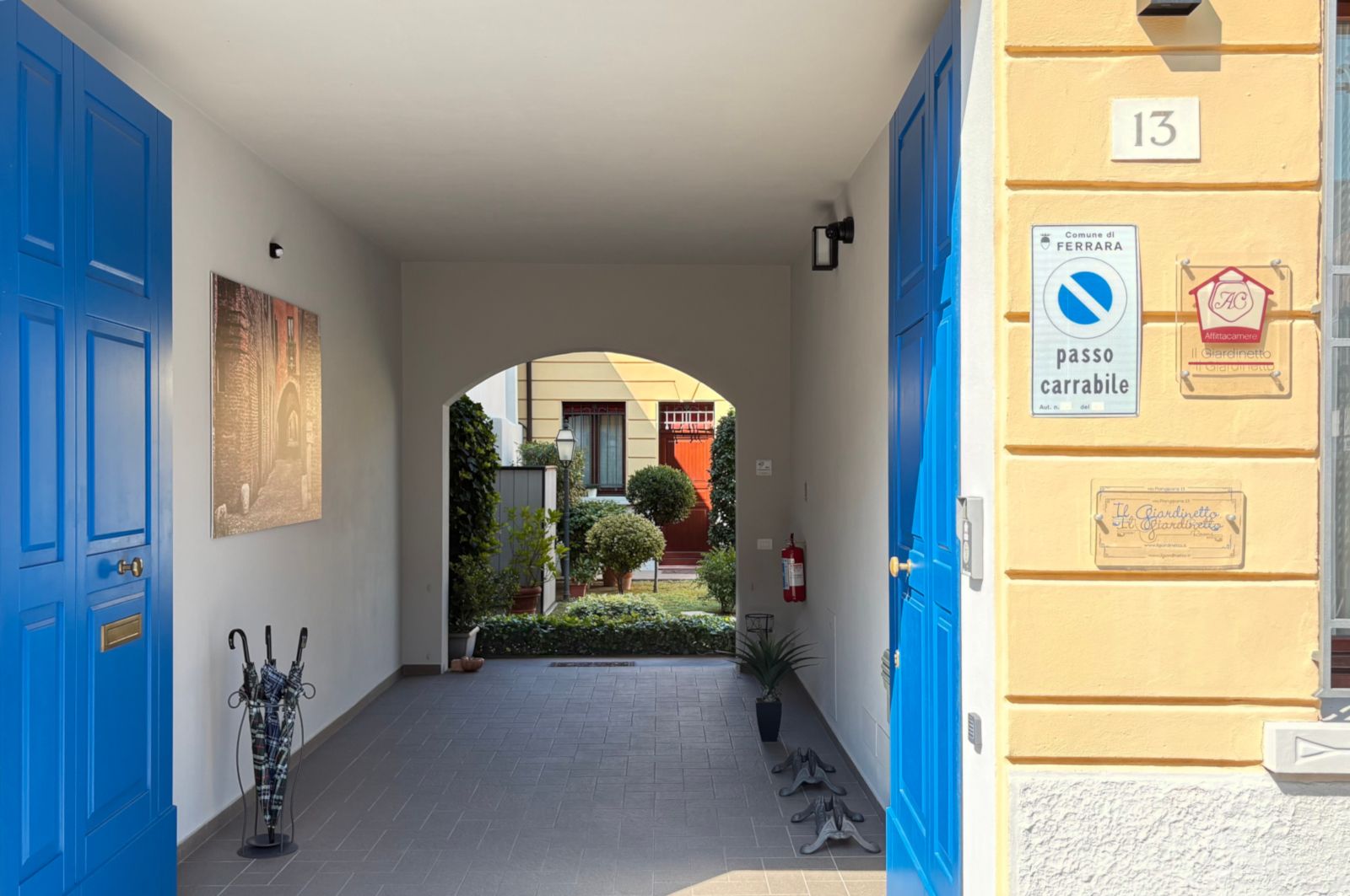Een gang met blauwe deuren, een brandblusser en een bord dat parkeren verboden aangeeft.