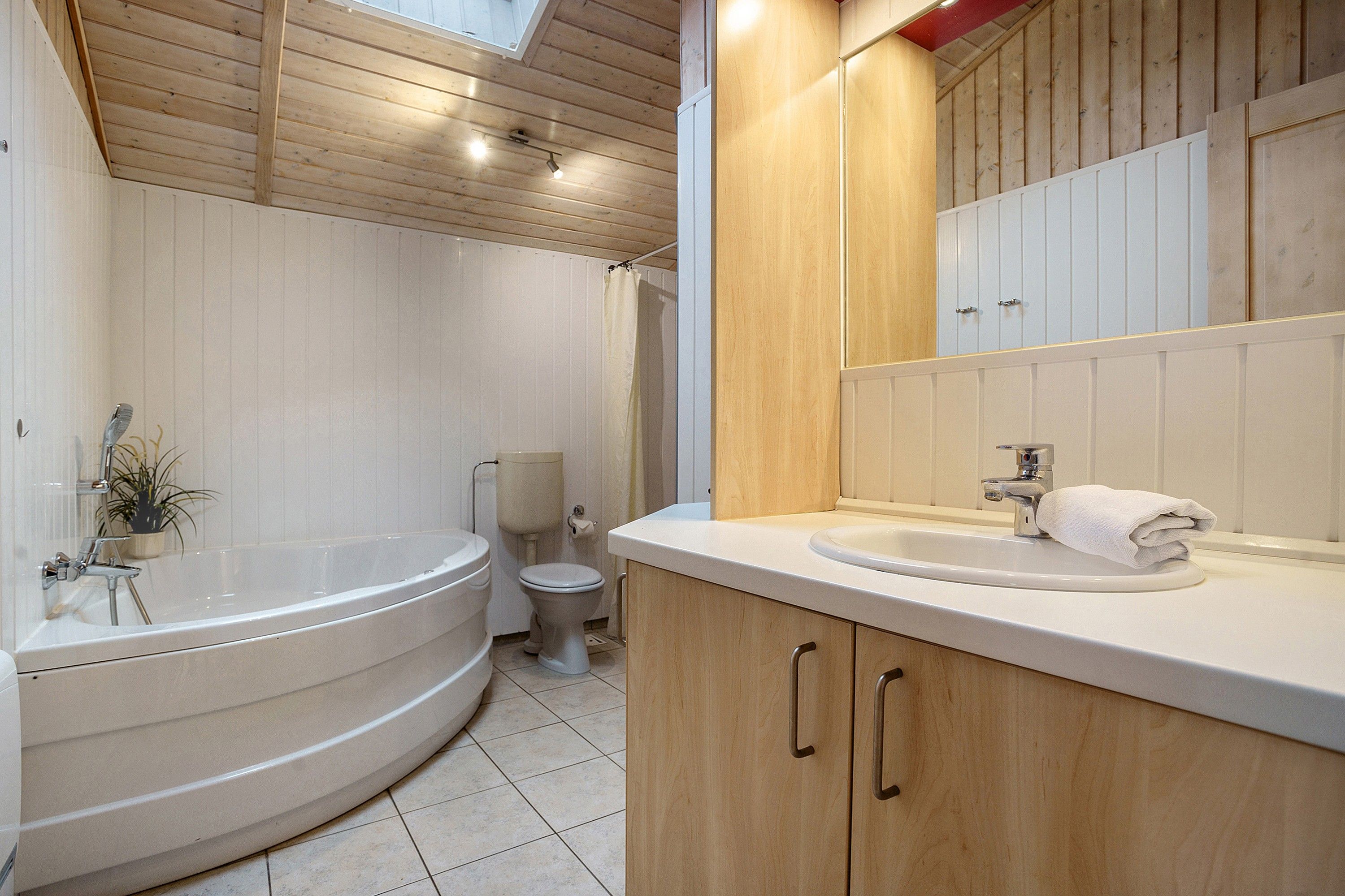 A bathroom with a freestanding bathtub, a sink with a towel, and a toilet.