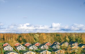 Un barrio residencial con varias casas, cada una con un estilo arquitectónico diferente, techos a dos aguas y una variedad de colores.