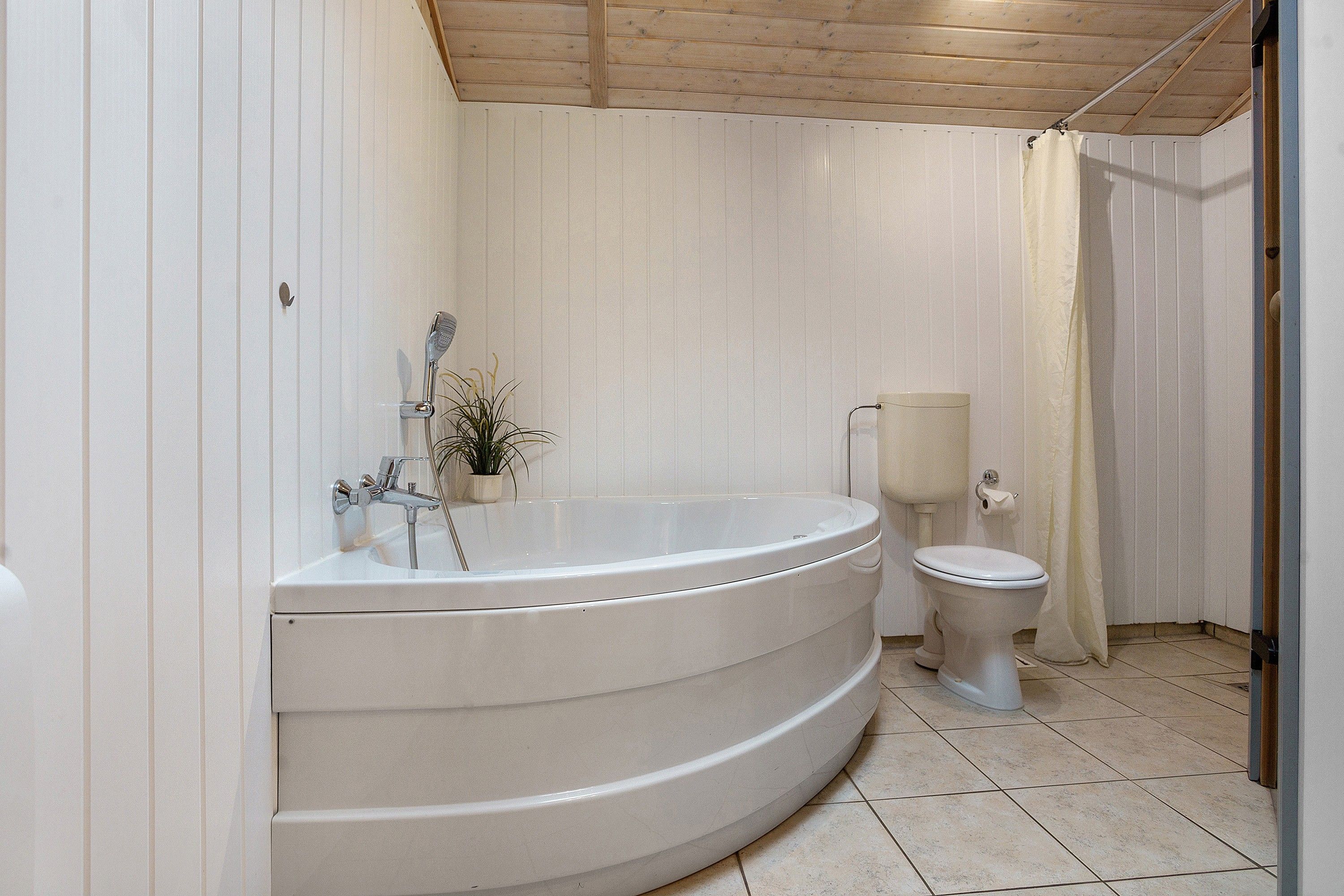 Une salle de bain avec une baignoire sur pieds, des toilettes et un rideau de douche.