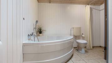 Une salle de bain avec une baignoire sur pieds, des toilettes et un rideau de douche.