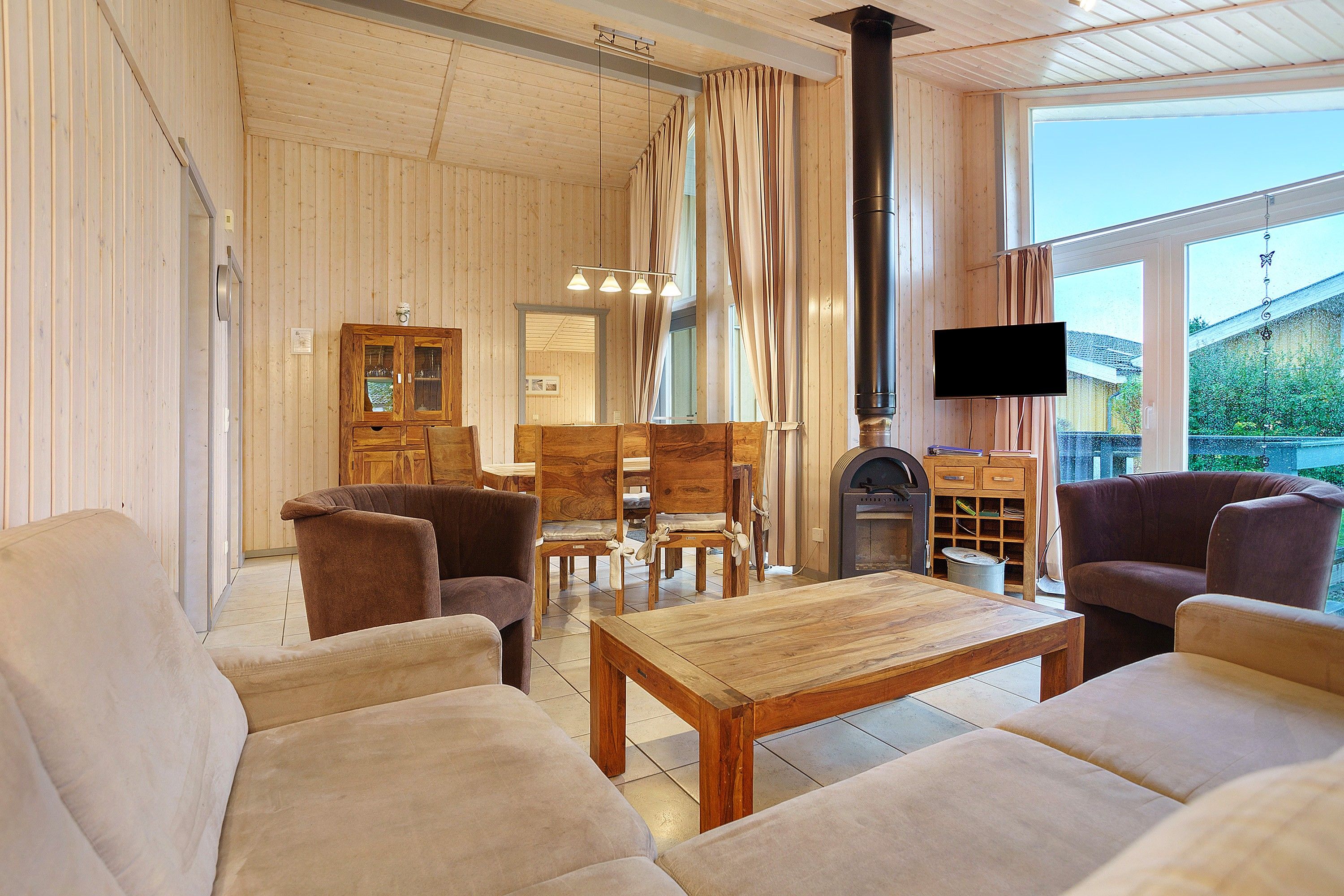 A cozy living room with wooden furniture, a fireplace, and a television.