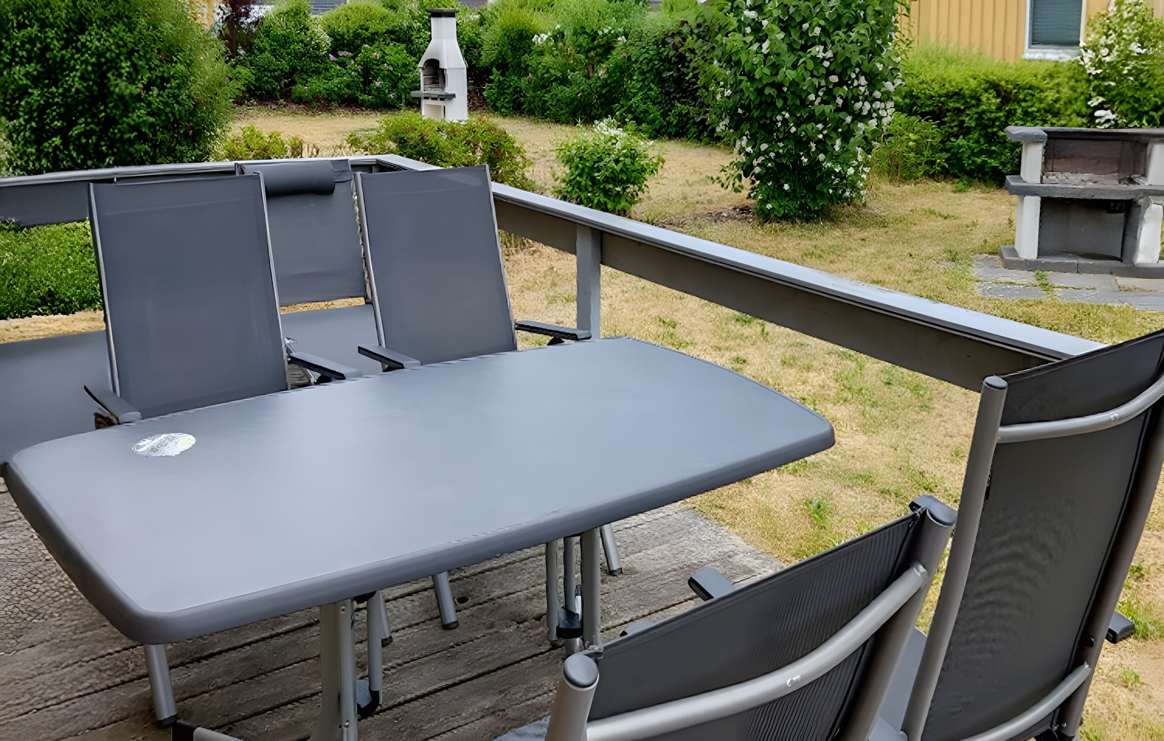 Eine Terrasse im Freien mit Tisch und Stühlen.