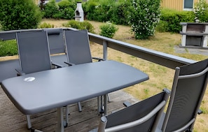 Un patio exterior con una mesa y sillas.