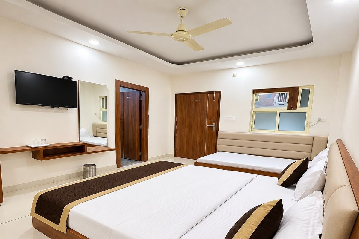 Habitación de hotel con una cama grande, televisión, armario y ventilador de techo.