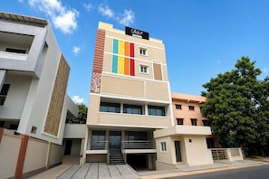 Edifício de vários andares com design arquitetônico moderno, destacando um padrão vertical em listras na fachada.