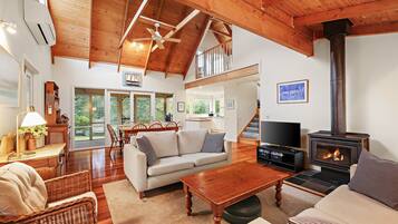 A spacious living room with a fireplace, a dining area, and a kitchen.
