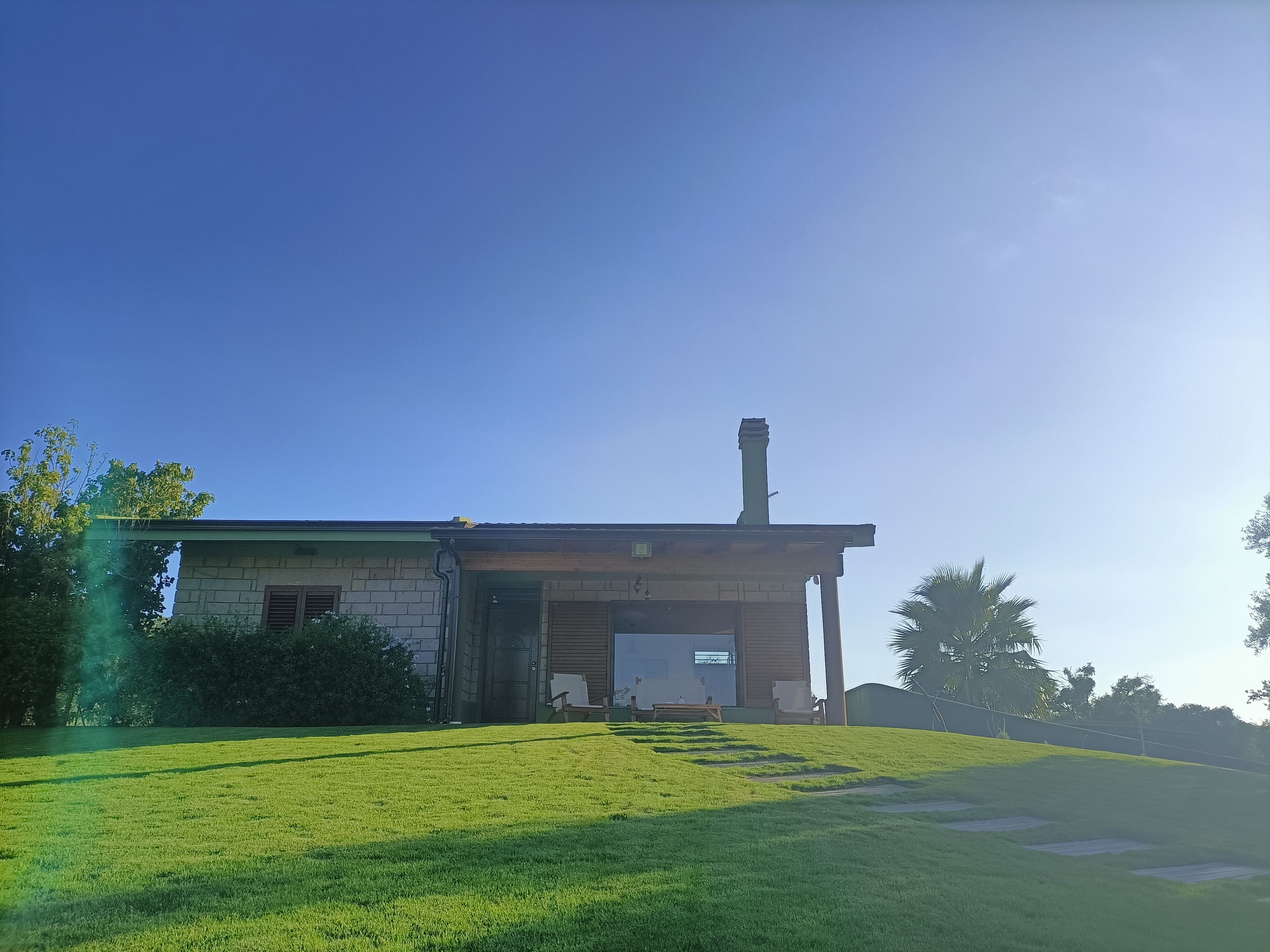 A house with a chimney, a front door, and a grassy yard.
