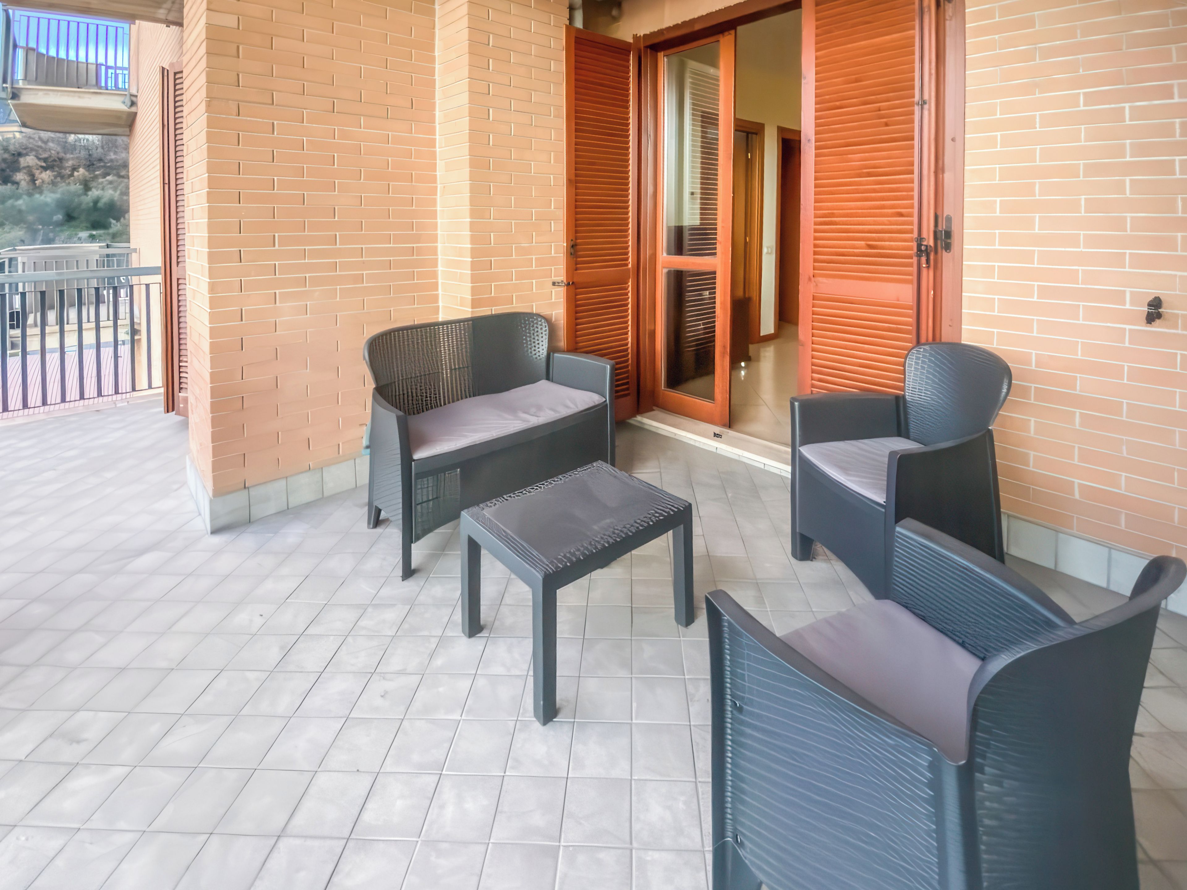 A balcony with a seating area consisting of two chairs and a small table.