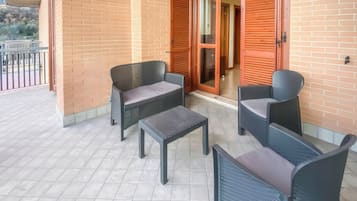 A balcony with a seating area consisting of two chairs and a small table.