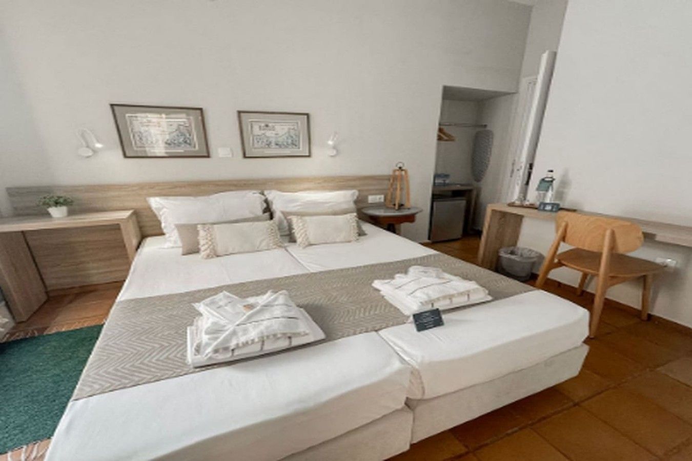 Une chambre d’hôtel avec un grand lit, des tables de chevet, un bureau et une chaise.