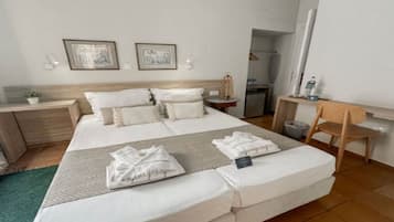 Une chambre d’hôtel avec un grand lit, des tables de chevet, un bureau et une chaise.