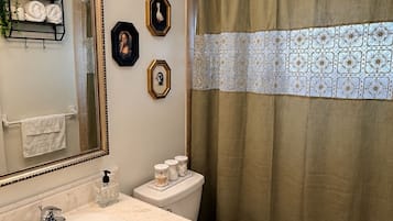 A bathroom with a sink, toilet, and shower curtain.