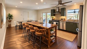 Una cocina moderna con una isla central, taburetes de bar y vistas al océano.