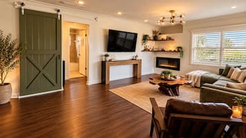 A living room with a fireplace, a television, and a large window.