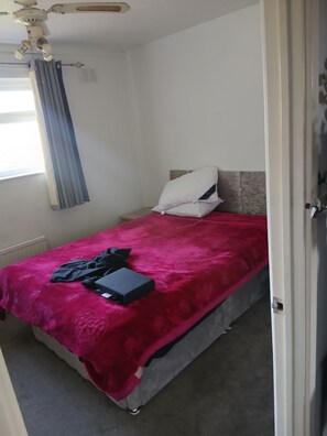 A bedroom with a bed, a ceiling fan, a window with curtains, and a door. - Mk apartment.  (Hodge Lea)
