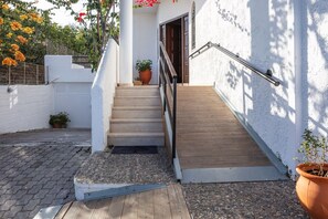 A staircase leading to a building with a white exterior and a wooden deck. - Sea views & full privacy Villa Aetos (Rethymno)