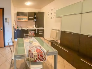 Une cuisine moderne avec une table à manger, des chaises et une horloge au mur.