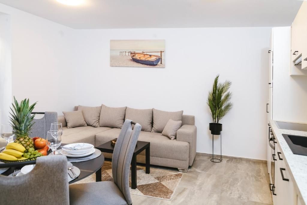 Un salón moderno con sofá, mesa de comedor y un cuadro de un barco en la pared.