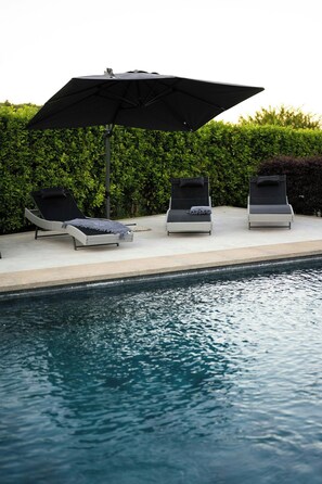 A poolside area with three lounge chairs and a large umbrella. - Villa with private pool, gym, games close to lake (Bracciano)
