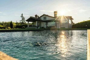 A house with a swimming pool in the foreground and a sun setting in the background. - Villa with private pool, gym, games close to lake (Bracciano)