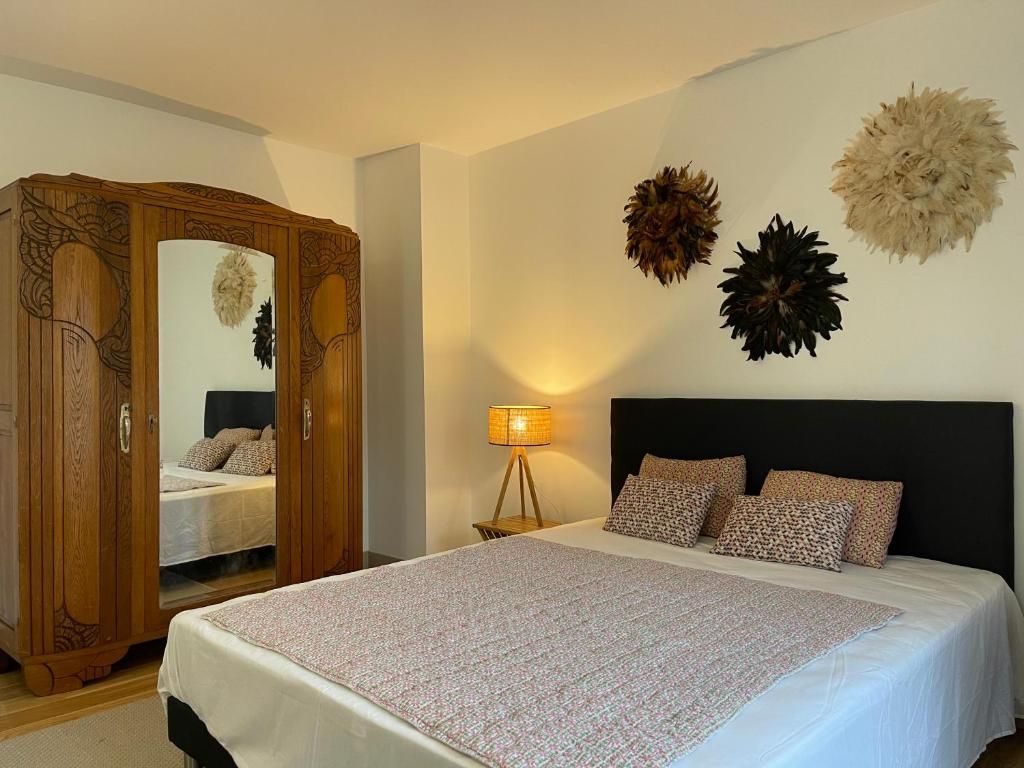 Une chambre à coucher avec un lit, une armoire, une lampe et des éléments décoratifs sur les murs.