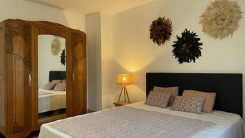 Une chambre à coucher avec un lit, une armoire, une lampe et des éléments décoratifs sur les murs.