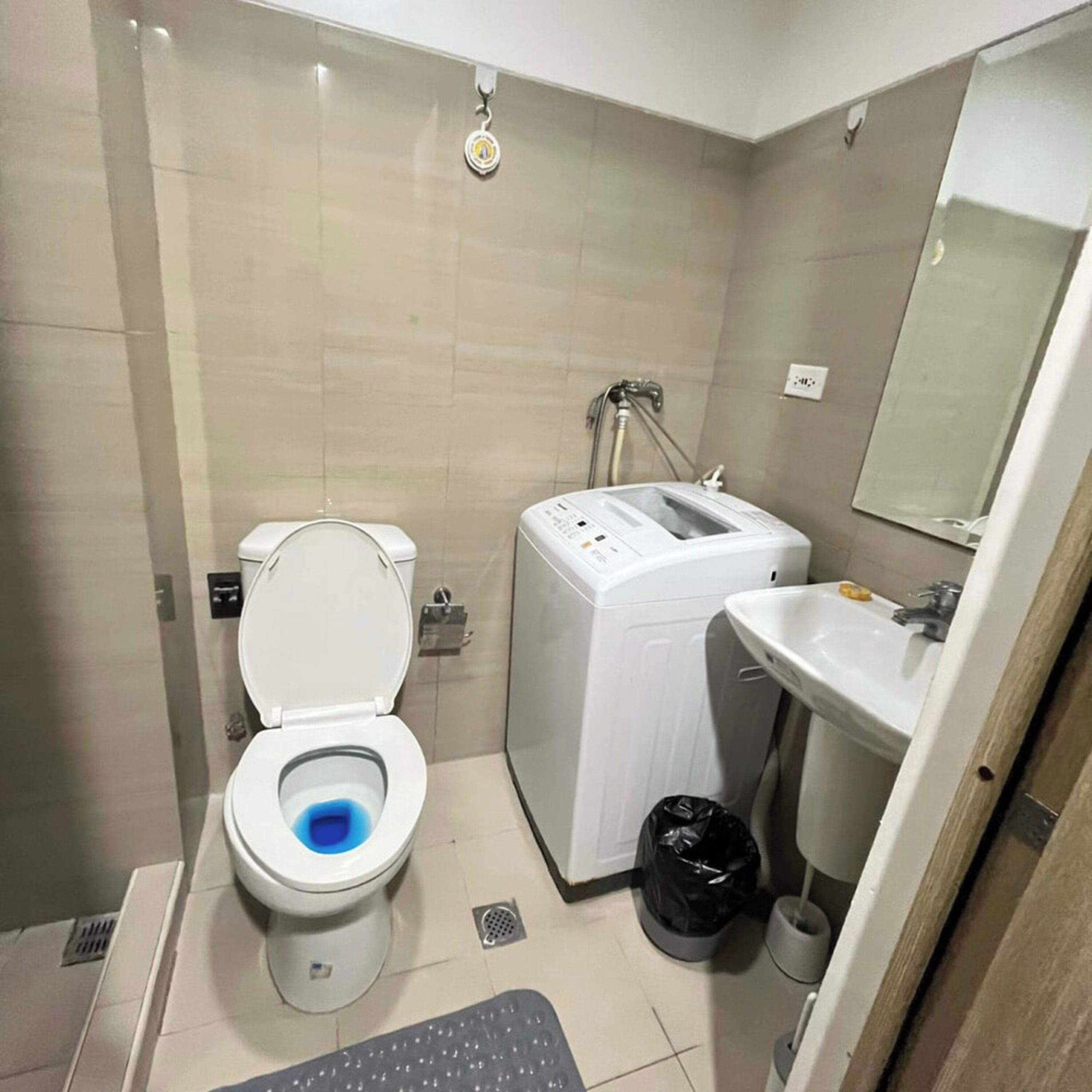 Un baño pequeño con inodoro, lavadora y lavamanos.