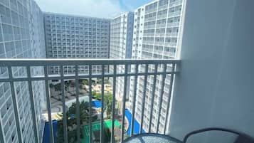 A balcony with a view of high-rise buildings and a pool area.