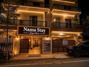 A multi-story building with a sign reading 'Nama Stay Signature.'