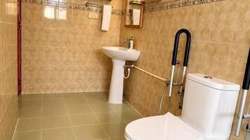 A bathroom with a toilet, sink, and shower.