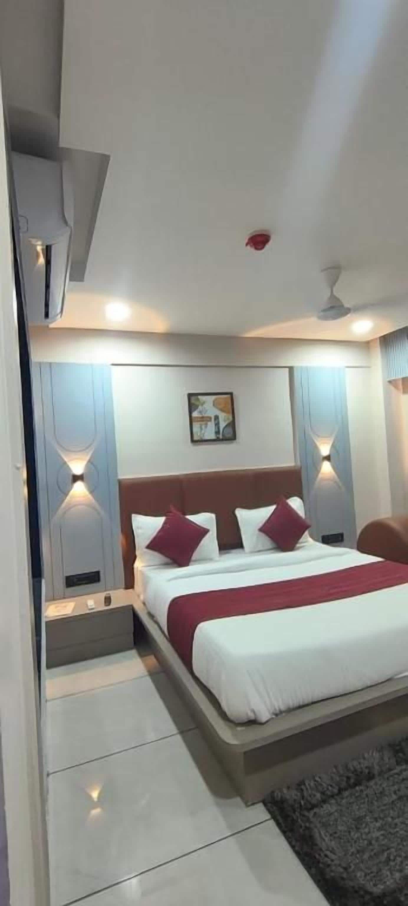 A modern bedroom with a bed, nightstands, and wall-mounted lighting.