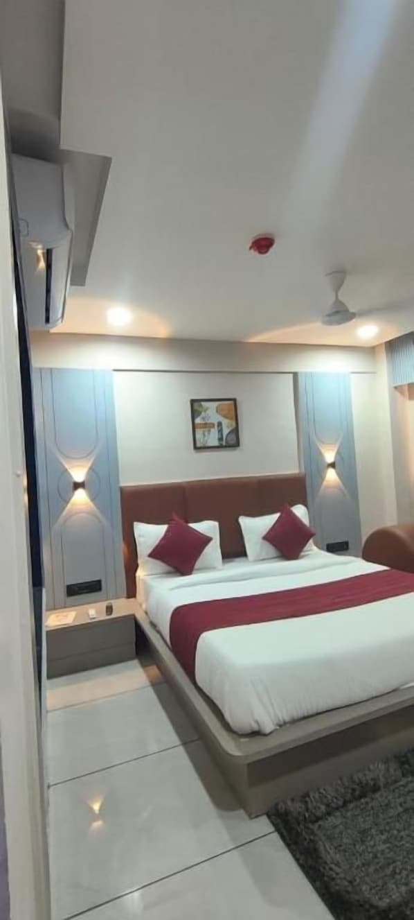 Un dormitorio moderno con cama, mesitas de noche e iluminación empotrada.