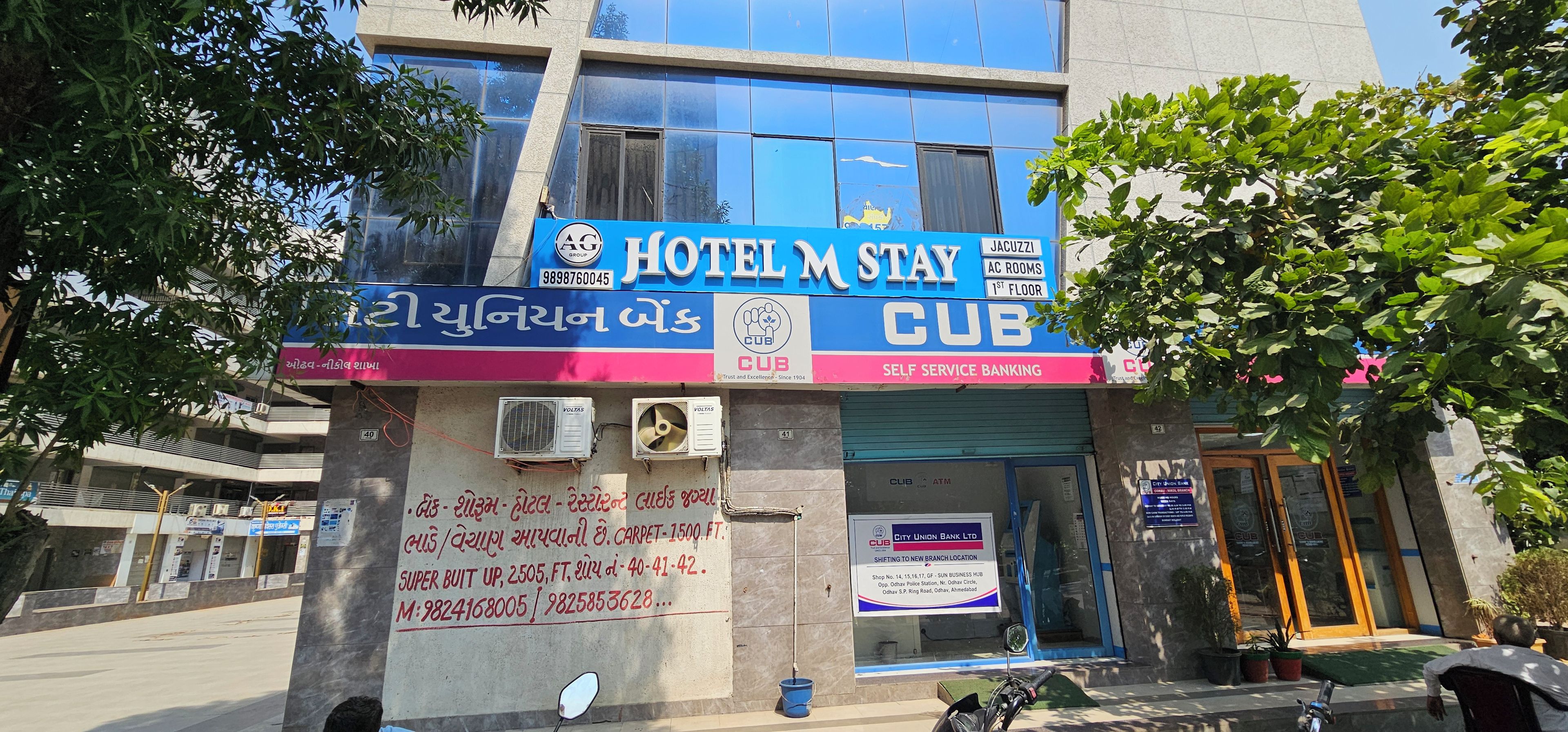 Un hotel con un letrero azul, unidades de aire acondicionado y el logotipo de City Union Bank.