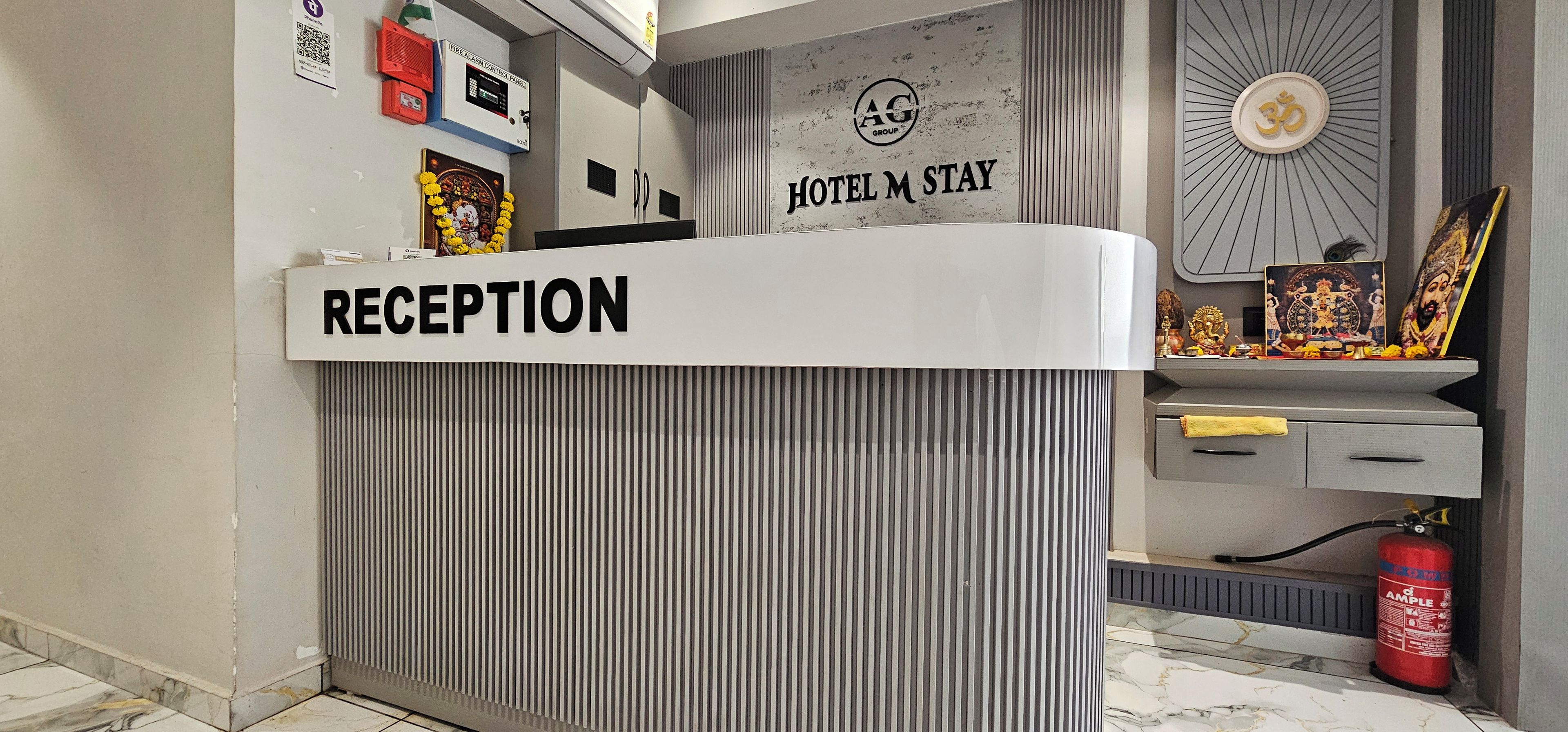 A reception desk with a sign that reads 'RECEPTION' and a 'HOTEL M STAY' sign above it.