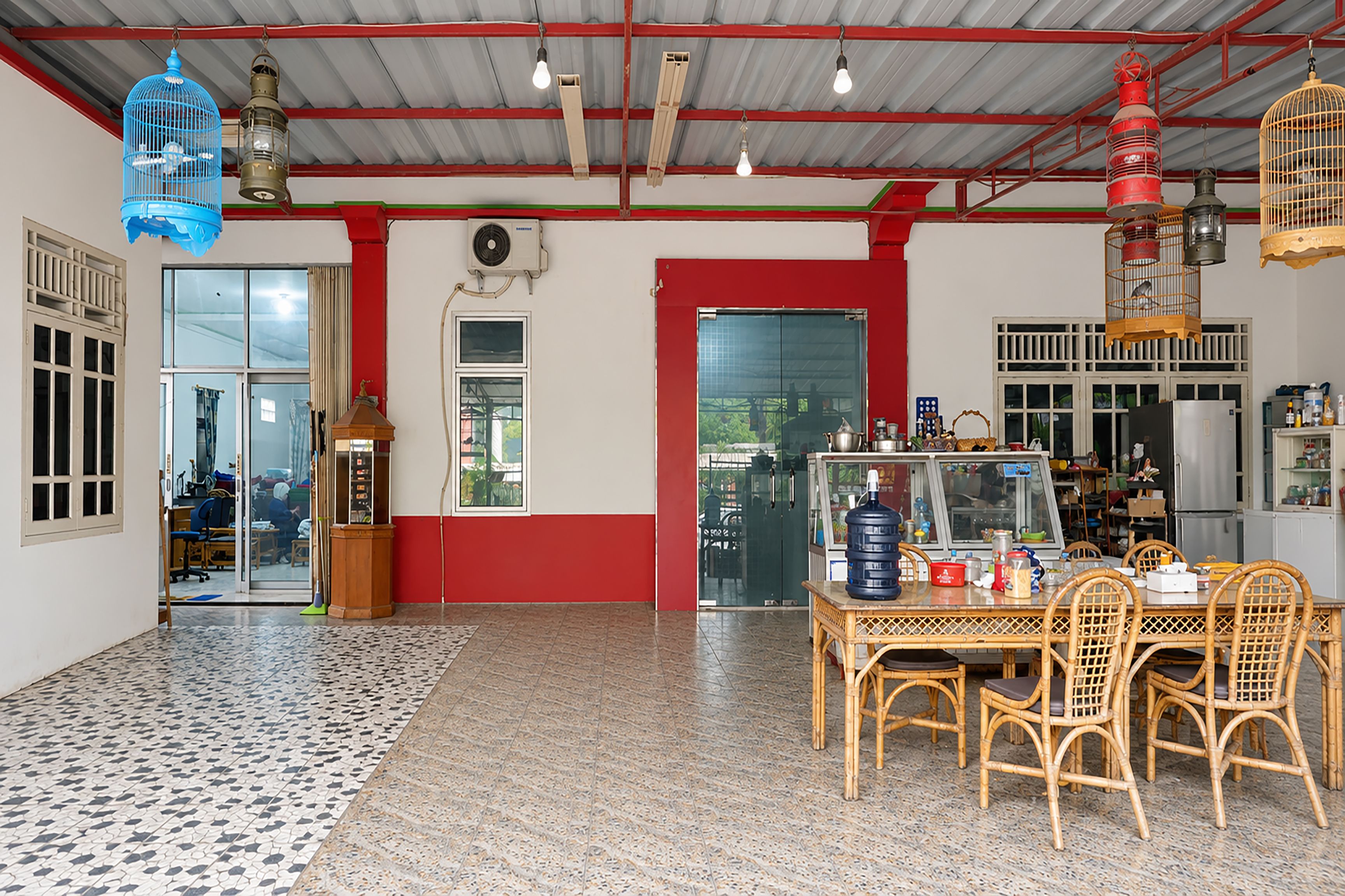 A room with a tiled floor, a table with chairs, a refrigerator, and a window with a view.