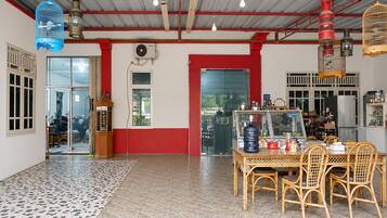 A room with a tiled floor, a table with chairs, a refrigerator, and a window with a view.